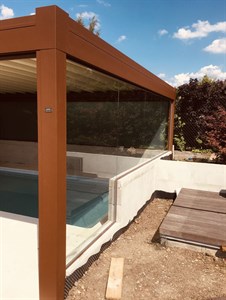 Dřevěná pergola se skleněnou stěnou u bazénu