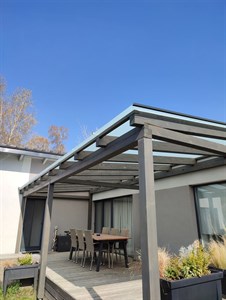 Kovová pergola se skleněnou střechou nad terasou